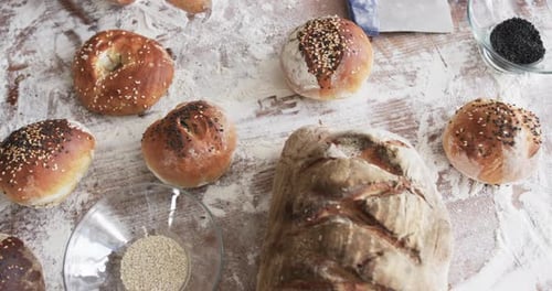 Close up of fresh and tasty rolls with seeds and bread on counter in slow motion