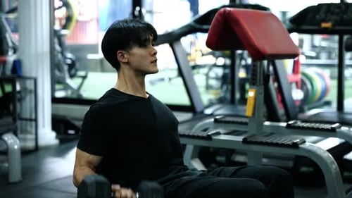 Muskulöser gesunder Mann, der Sport im Fitnessstudio trainiert
