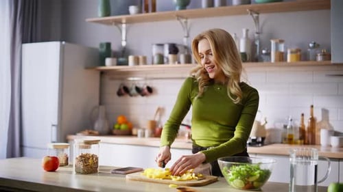 Woman Prepares Healthy Salad in Bright Kitchen