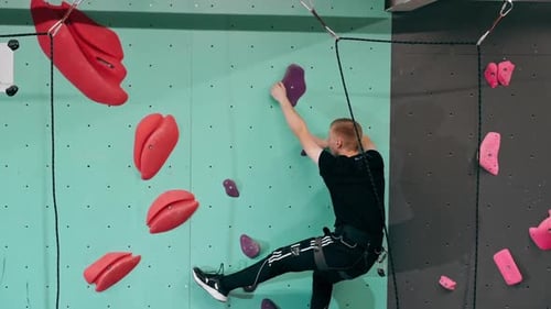 Man Climbing Indoor Rock Wall for Exercise