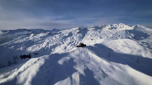 Drone shot of snowy Swiss alps with gondola station, Laax, Switzerland