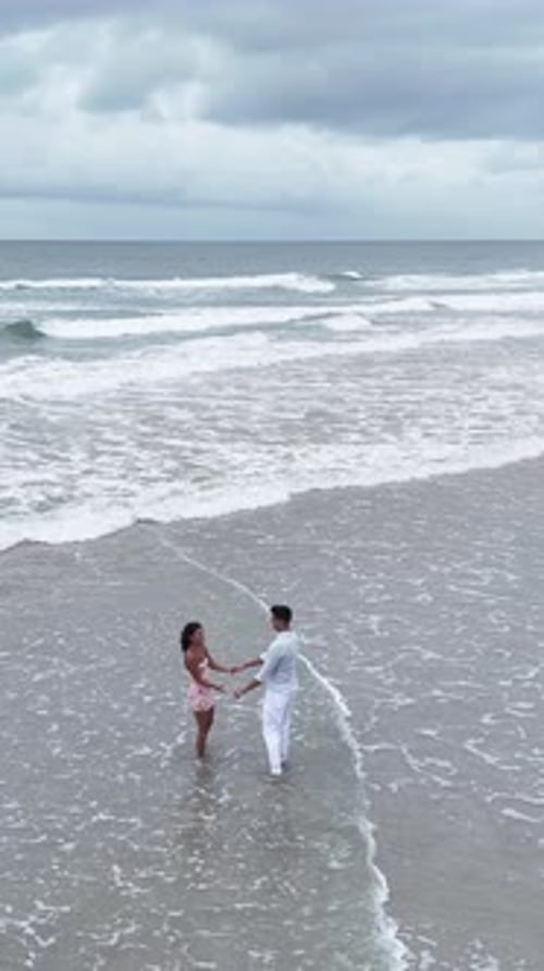 Romantic Interracial Couple Dancing in Ocean Waves