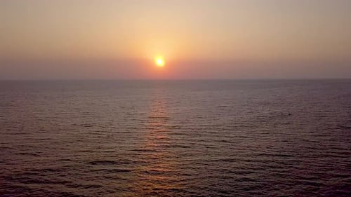 Seitliche Luftaufnahme des Sonnenuntergangs über dem weiten Ozean