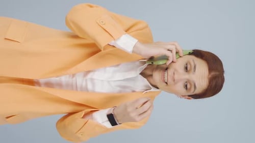 Woman in Suit Talking on Phone Vertically