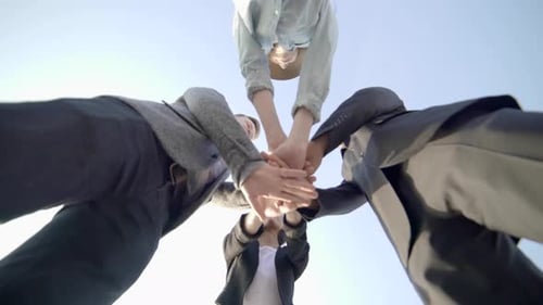 group of friends showing team spirit handshaking and cheering together