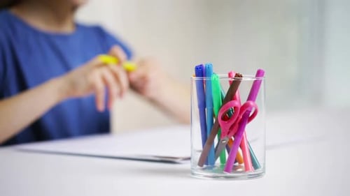 Child Drawing with Markers at White Table