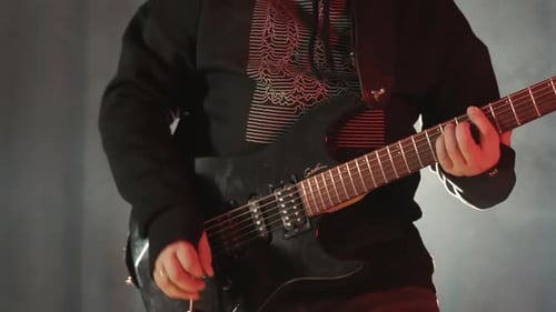 Silhouette of a Guitarist on a Dark Stage with Smoke Playing Rock