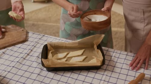 Child and Adults Bake Cookies Together in Kitchen