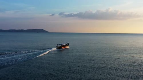 Motorboat Gliding Across Calm Ocean at Sunrise