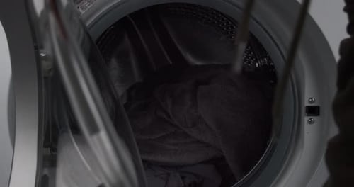 Person closing washing machine door, ready to wash clothes, close up