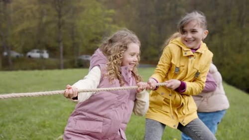 Niños de primaria disfrutan de una competencia de tirar de la cuerda en la naturaleza
