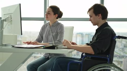 Kollegen Geschäftsleute Frau Mann im Lehrstuhl für Menschen mit Behinderung arbeiten an einem Büro-Startup