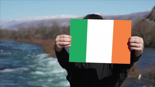 Person, die ein Banner mit der Flagge Irlands hält