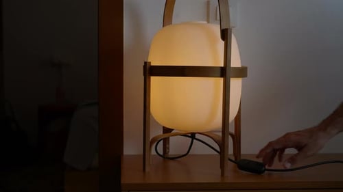 Mit einer Hand wird ein wunderschön gestaltetes Licht ausgeschaltet, das statisch ist und Platz zum Kopieren bietet.