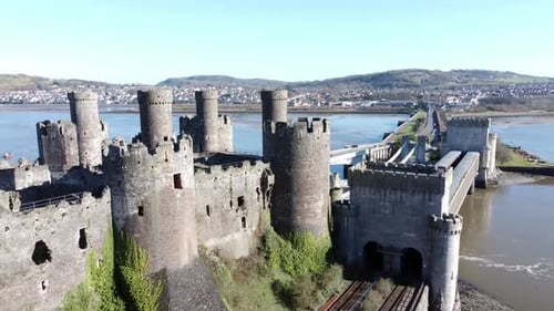 Medieval Conwy castle Welsh market town ruins aerial descending view to railway tracks