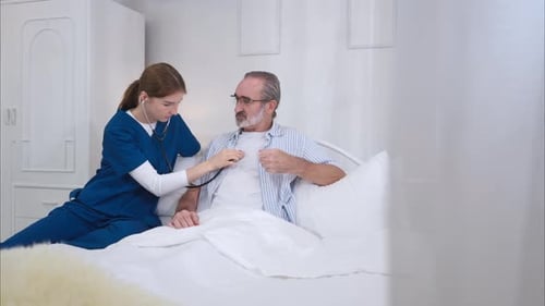 Attentive Nurse Examines Senior Man Patient with Stethoscope