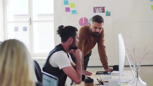 Young business team collaborating on laptop in modern office space