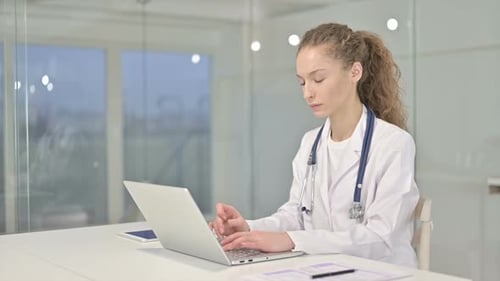 Ambitious Young Female Doctor Working on Laptop in Office