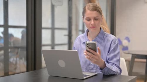 Young Woman Using Multiple Digital Devices in Office