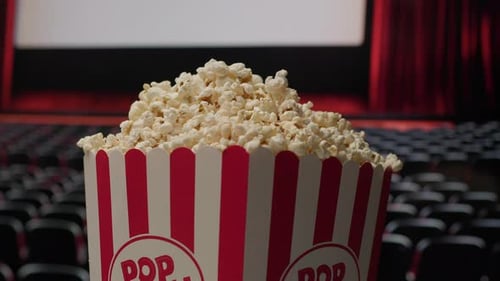 Rotating Popcorn Basket with Cinema Screen in Background