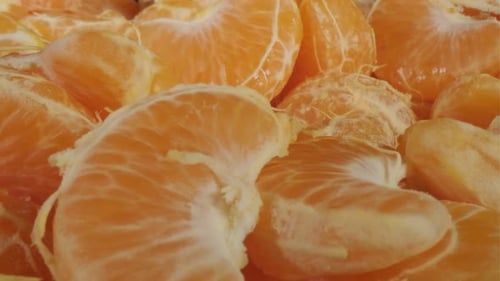 Geschälte Mandarinen auf schwarzem Hintergrund Mandarinen- oder Mandarinenfruchtscheiben in Nahaufnahme