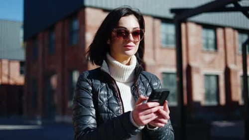 Woman Using Cellphone Outdoors in an Urban Setting
