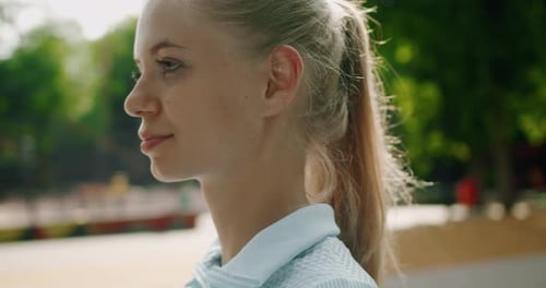 Portrait of Young Attractive Woman Walking in Park and Looking at Camera