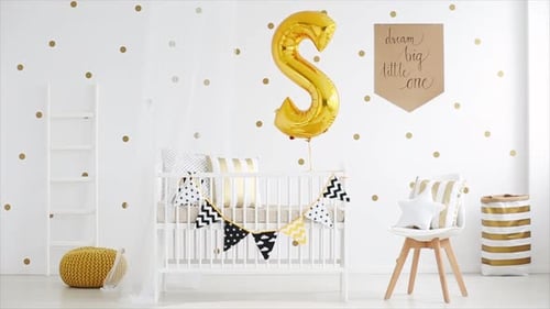 Cute fully furnished baby room with golden balloon decor and wooden crib