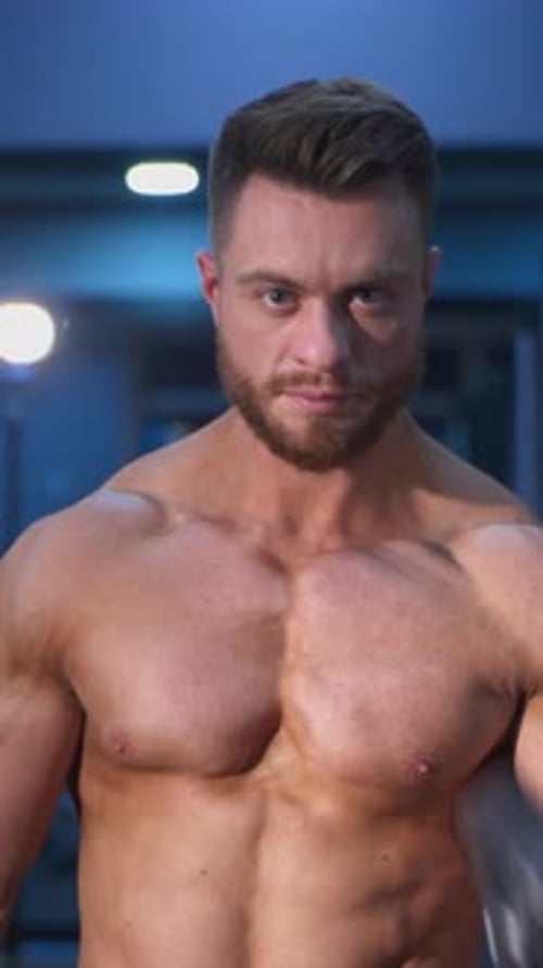 Homem musculoso de fitness treinando seus bíceps na academia. Belo fisiculturista trabalhando duro na academia
.