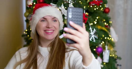 Woman Video Chatting at Christmas Time Indoors