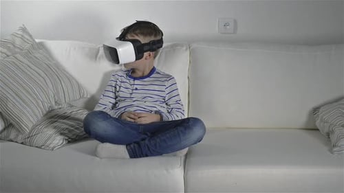 Boy Using Virtual Reality Headset While Sitting on Couch