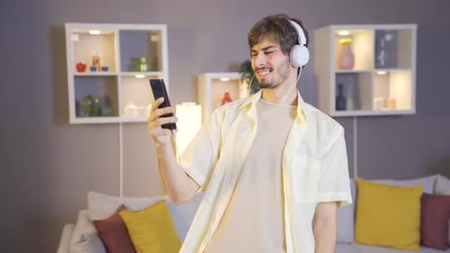 Cheerful Man Listening to Music and Dancing Indoors