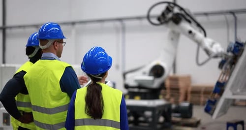 Gemischtrassige Ingenieure arbeiten in einer Roboterfabrik mit digitalem Tablet African