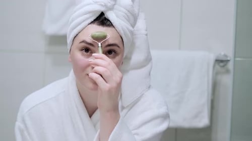 Woman Using Jade Roller for Facial Massage