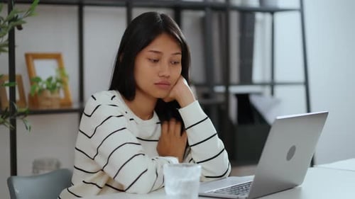 Woman feeling mentally exhausted and unmotivated while working remotely.