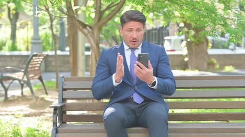Middle Aged Businessman Reacting to Failure on Phone Outdoor
