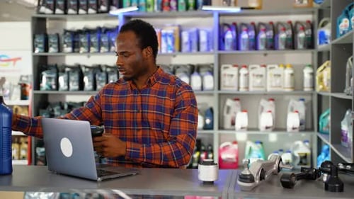 Man Scanning Barcode at Workplace with Laptop