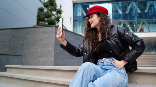 Young Woman Video Chatting on City Steps