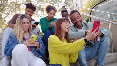 Young Adults Smiling Using Phones in Urban Setting