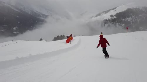 Snowboarder fahren am Berghang