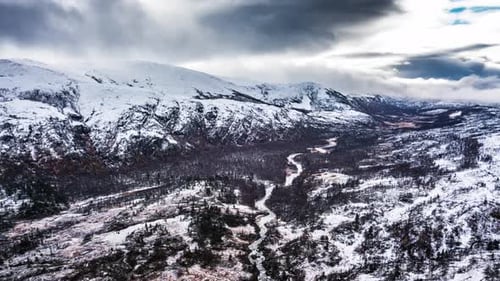 An aerial view of the Gåsvatnan park, Norway. The valley is covered with fresh snow, the river is me