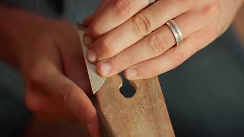 Craftsman sharpening a metal blade using traditional tools in a workshop environment