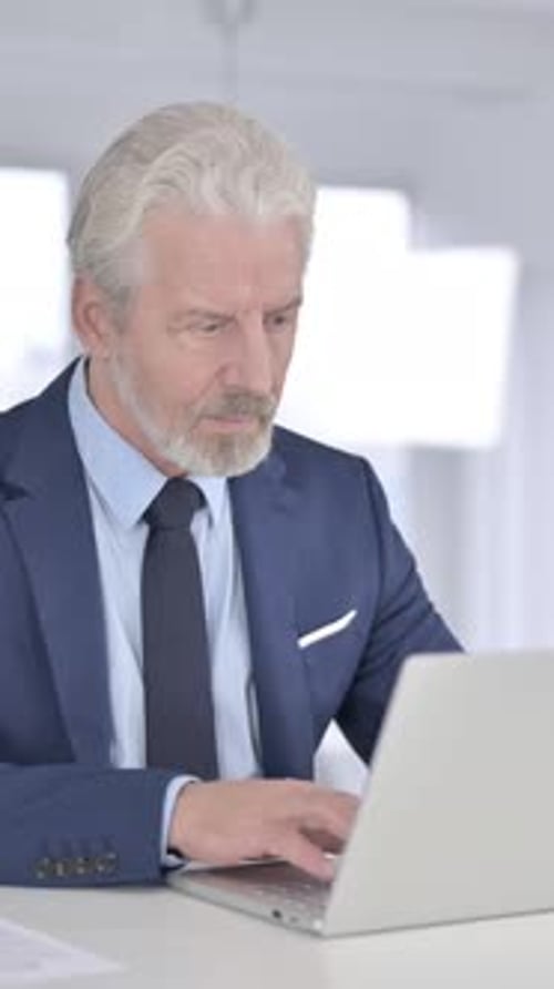 Mature Man Working on Laptop in Office