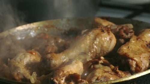 Chicken Drumsticks Frying in a Pan on Stove