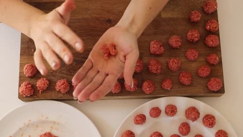 Woman Making Meatballs on Wooden Board in Kitchen