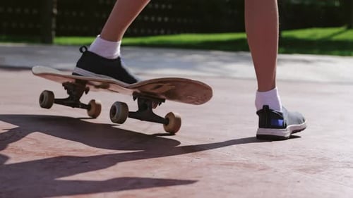 Legs Performing Kickflip on Skateboard in City Park