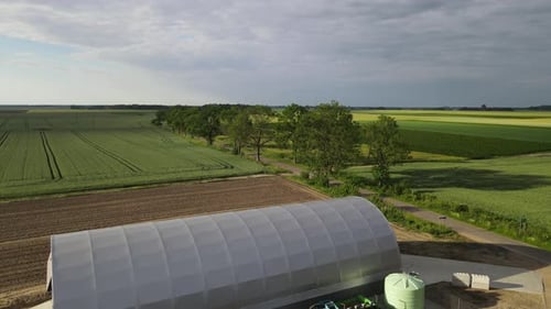 arched hall storage warehouse production farm facility in field sunny