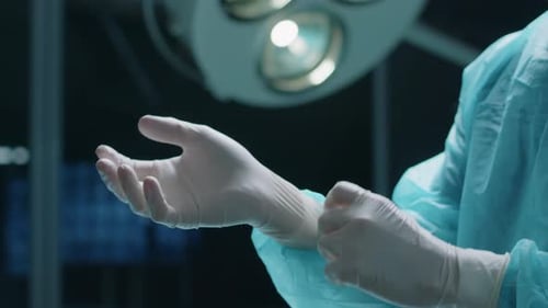 Surgeon Puts on Surgical Gloves in Operating Room