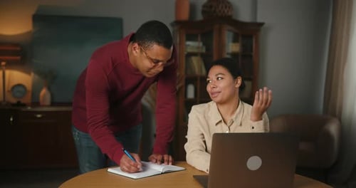 Collaborating Couple Working Together on Laptop Project