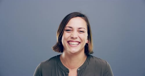 4k video footage of a woman laughing against a gray background